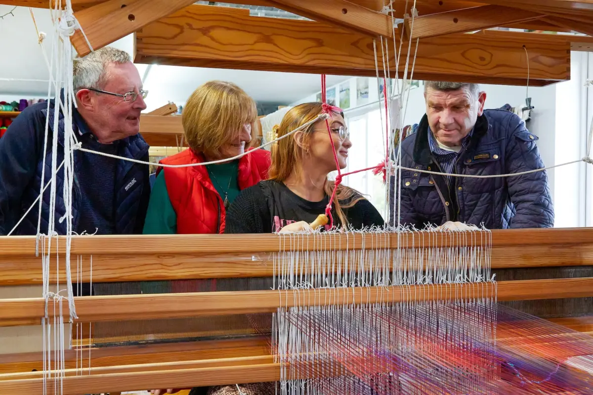 tourists-enjoy-handweaving-demonstration-in-liz-christy-studio